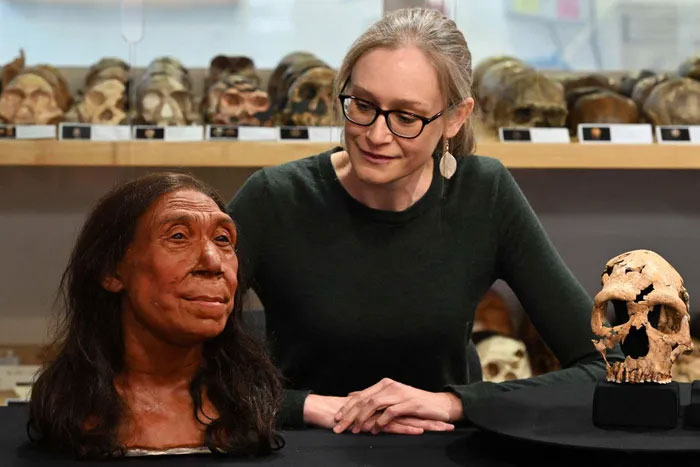 Phó giáo sư Emma Pomeroy chụp ảnh với hộp sọ và khuôn mặt được tái tạo của một phụ nữ Neanderthal sống 75.000 năm trước tại Đại học Cambridge, Anh. (Ảnh: AFP).