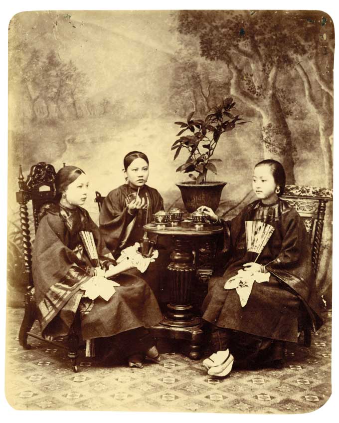 Bức hình ba phụ nữ thưởng trà, chụp những năm 1890. Họ mặc đồ tươm tất, cách bài trí nhà, dụng cụ uống trà cho thấy họ thuộc thành viên gia tộc giàu có. Các nhiếp ảnh gia tìm được tư liệu cho biết ảnh chụp ở Quảng Đông, họ là ba người vợ của một viên quan triều đình.