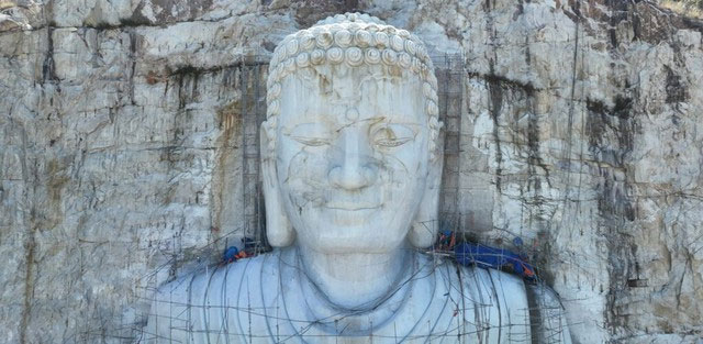 Hiện tại, tượng Phật đã hoàn thiện được phần thân trên, riêng phần chân và tòa sen đang tiếp tục được điêu khắc hoàn thiện. (Ảnh: Trịnh Cường)